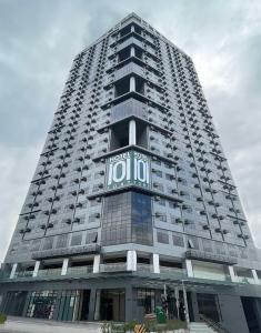 马尼拉Hotel101 - Fort的一座高大的建筑,旁边是钟