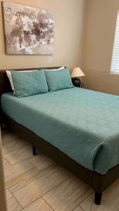 哈瓦苏湖城Paradise Oasis! Waterfall pool & spa的一间卧室配有一张带绿床单和枕头的床。