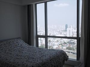 马尼拉Modern and Comfortable Staycation - Unit 3718 Novotel Tower的一间卧室设有一张床和一个大窗户