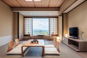 守山琵琶湖万豪酒店的客厅配有电视和桌椅