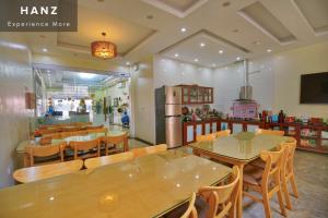 河内HANZ Noi Bai Airport Hotel的一间设有木桌和椅子的餐厅
