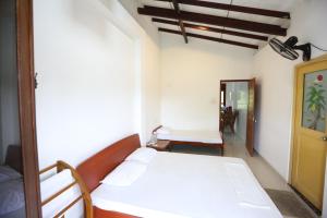 NelluwaSinharaja River Face Hotel的卧室配有白色的床