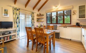 TasmanTasman Village Cottage的厨房以及带木桌和椅子的用餐室。