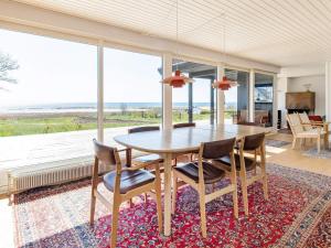 阿森斯Holiday home Assens IX的一间带桌椅和大窗户的用餐室