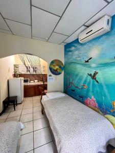 阿约拉港Nelyza's Suites & Adventure的一间设有一张床的客房,墙上挂着一幅画
