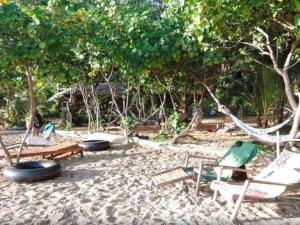 俊穆岛Room in Bungalow - Breathtaking Cottage of Koh Pu的树荫海滩上的吊床和椅子
