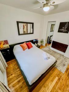 隆格伊Barel Home Residence的一间卧室配有带白色床单和橙色枕头的床。