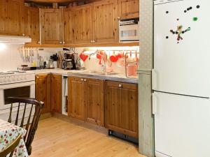 埃克舍Holiday home EKSJÖ II的厨房配有木制橱柜和白色冰箱。
