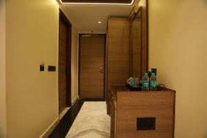 大诺伊达Lime Tree Hotel and Banquet Greater Noida的走廊上设有门,柜台上装有两瓶