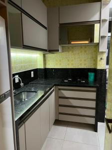 里约热内卢Solar Del Passo的厨房配有白色橱柜和水槽