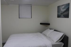 沃恩Comfyhome的卧室内的一张白色床,设有窗户