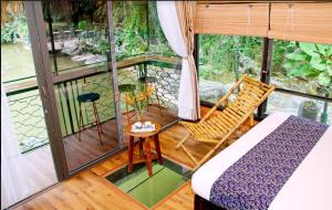 宁平Tam Coc Lion Kings Hotel & Resort的带阳台的客房配有一张床和椅子