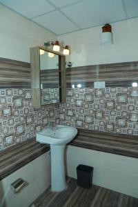 古鲁瓦尤尔Utsavam Hotel Apartments的一间带水槽和镜子的浴室