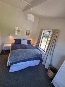 瓦纳卡Cottage on Matai的一间卧室设有一张大床和一个窗户。