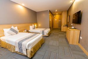 马尼拉麦迪逊塔楼101酒店的酒店客房设有两张床和一台平面电视。