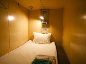 东京Capsule Hotel Block Room的小房间设有床和枕头