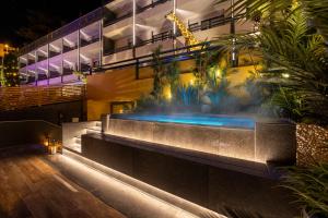 特伦托Hi Hotel - Wellness & Spa的一座晚上设有游泳池的建筑