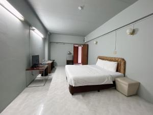 曼谷Win Mansion的一间卧室配有一张床、一张书桌和一台电视
