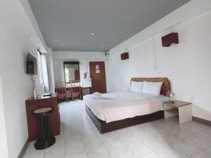 曼那โรงแรมวินบางนา Win Bangna Hotel的一间卧室配有一张床和一台电视。