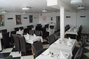 科隆弗赖海特酒店的用餐室配有白色桌子和黑色椅子