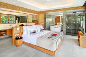 乌布Kaamala Resort Ubud by Ini Vie Hospitality的一间带大床的卧室和一间浴室