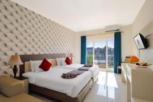 库塔The Kanjeng Hotel Kuta的酒店客房设有两张床和窗户。