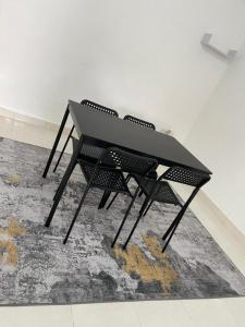 樟仑Homestay Merbau Changloon的地毯上的一张黑桌子和两把椅子