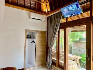 乌布Sridewi Villas Ubud的客房设有冰箱和天花板上的电视
