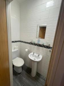 米尔顿凯恩斯Abbey Guest House的白色的浴室设有卫生间和水槽。