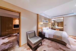 银川银川西府井饭店的一间卧室配有一张床、一把椅子和镜子