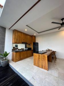 乌布Gyanesh Villa的厨房配有木制橱柜和黑色台面