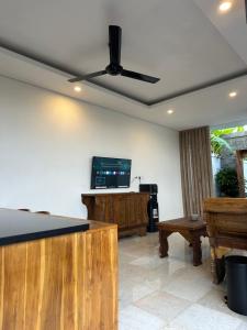 乌布Gyanesh Villa的客厅配有吊扇和电视。