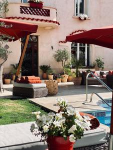 Cuxac-dʼAudeVilla Maskali的一个带游泳池、红伞和鲜花的庭院