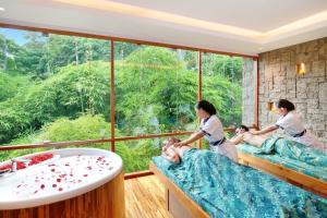 乌布Kaamala Resort Ubud by Ini Vie Hospitality的一间带2位女性床和浴缸的spa室