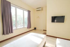 当格浪Athena Syariah Residence的客房设有床和大窗户。