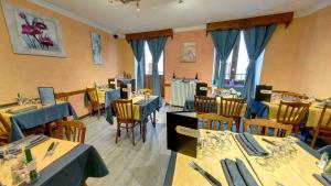 巴斯洛内特杜切瓦布兰克酒店的一间设有桌椅的餐厅,拥有蓝色和黄色