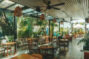 三亚三亚IPK背包客旅舍的一间设有桌椅的餐厅,种植了植物