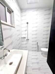 拉合尔Hotel Grand Pakeeza的白色的浴室设有水槽和卫生间。