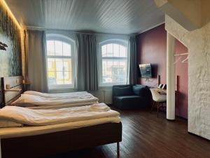 劳马Hotel Sleep at Rauma的酒店客房,设有两张床和一张沙发
