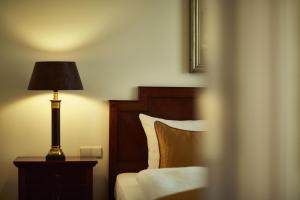 居特斯洛居特斯洛公园酒店的一间卧室配有一张床和一张桌子上的台灯
