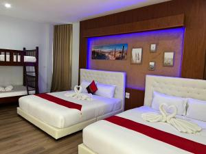 合艾大河酒店的一间卧室配有两张床和一张双层床。