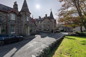 皮特洛赫里The Bank House at Scotland's Hotel的停在大楼前的汽车