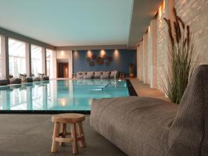 蒂门多弗施特兰德Grand Hotel Seeschlösschen Sea Retreat & SPA的客厅设有1个带1张沙发和1把椅子的游泳池
