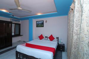 RāmpuraOYO 13161 Apni Havali Hotel & Restaurant的一间卧室配有一张带红色枕头的大床