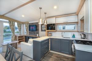 塞顿港Luxury 8 Berth-Wheelchair Access的厨房以及带蓝色橱柜和沙发的客厅。