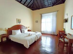 巴列埃尔莫索Tamahuche Hotel Rural的一间卧室设有一张床和一个大窗户
