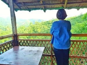 塔奈MIRA AgroPark的站在一个眺望着山脉的阳台上的女人