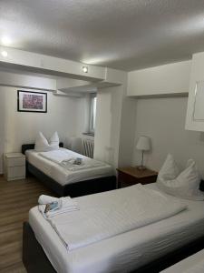 波恩波恩GZ旅馆的酒店客房,配有两张带白色床单的床