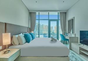 迪拜First Class Apartments in Seven Palm with direct Access to the West Palm Beach and Nakheel Mall的卧室配有一张白色大床和一张书桌