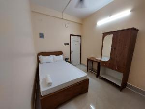 古瓦哈提Hotel Hari Gayatri Regent的一间小卧室,配有一张床和镜子
